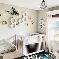 a baby's room with hexagonal decorations on the wall and a crib