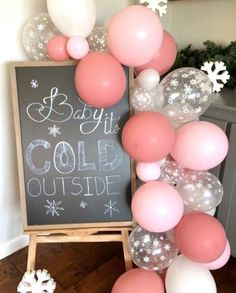 a baby it's cold outside sign with balloons and snowflakes around it