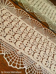 two crocheted doily sitting on top of a wooden table