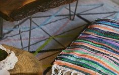 a wooden bench sitting on top of a rug next to a piece of wood and metal