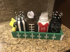 three jars with toothbrushes and combs in them sitting on a counter top