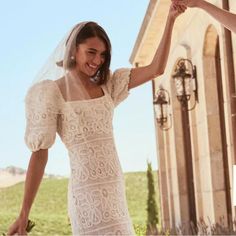 two women in wedding dresses holding hands and smiling