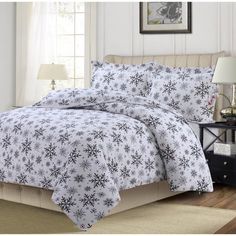 a bed with white and black snowflakes on it