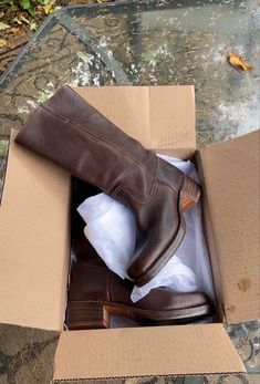 a pair of brown shoes in a cardboard box