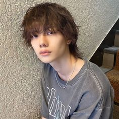 a young man is sitting on the stairs with his hand on his hip and looking at the camera