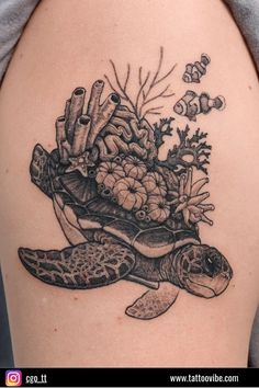 a woman's arm with a tattoo of a turtle and corals on it