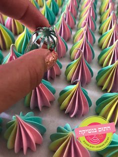 someone is decorating colorful paper flowers with a ring in their hand on a table