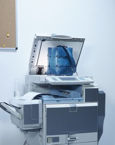 an open laptop computer sitting on top of a printer