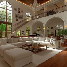 a living room filled with white furniture and lots of windows on top of the walls