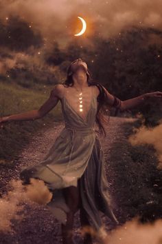 a woman in a dress is walking down a path with her arms outstretched and the moon above her head