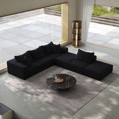 a black sectional sofa sitting on top of a rug