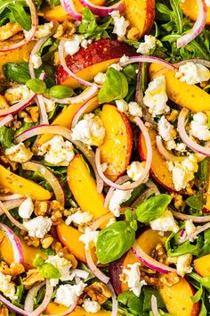 a salad with peaches, feta cheese and spinach on top is shown