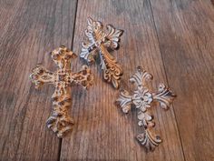 three wooden crosses sitting on top of a wooden floor