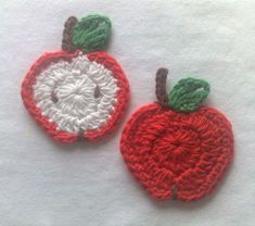 two crocheted apples sitting next to each other on top of a white surface