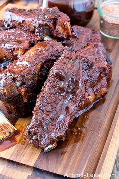 barbecue ribs on a cutting board with bbq sauce