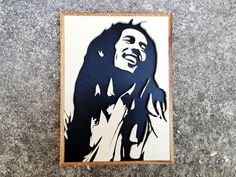 a painting of a man with dreadlocks on his head is hanging on the wall