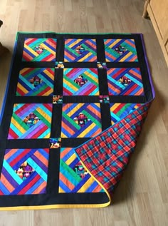 a multicolored quilt is laying on the floor