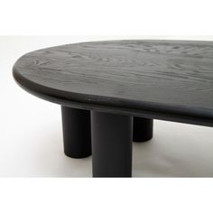 an oval table with black metal legs on a white background