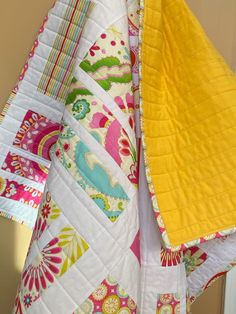 the quilts are all different colors and patterns on the table cloth, as well as one yellow piece of fabric