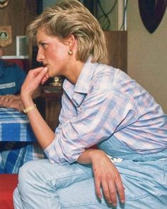 a woman sitting on top of a red couch next to a man in a blue shirt