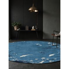 a blue rug with white clouds on it in a room next to a chair and table