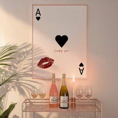 a table with wine glasses and bottles on it in front of a poster that says i love you