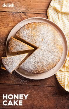 a cake on a plate with the words honey cake in front of it and a slice missing