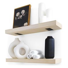 some white and black vases are sitting on the shelf next to other decorative items