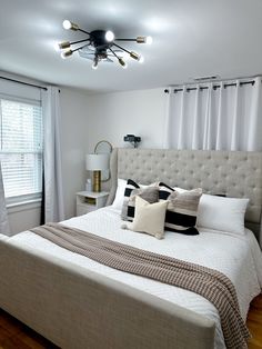 a bedroom with a large bed and white curtains