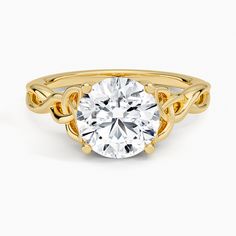 a yellow gold engagement ring with a round cut diamond in the center and twisted band around it