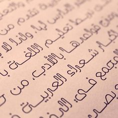 closeup of arabic writing on white paper with black letters and cursive numbers