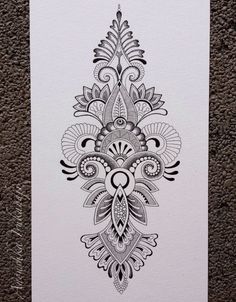 an intricately designed piece of paper on the ground, with black and white ink