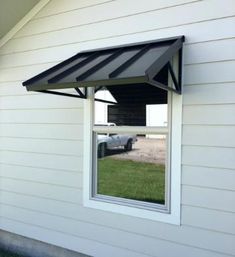 an awning on the side of a house with a car in the window behind it