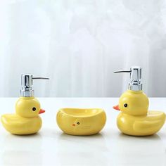 three soap dispensers with yellow ducks on them sitting next to each other