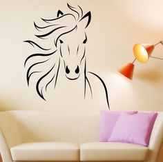 a living room with a white couch and a black horse wall decal