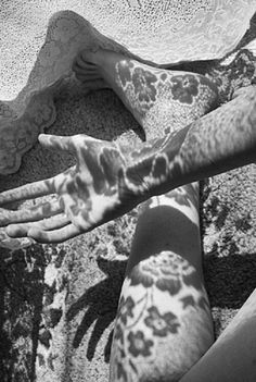 a woman laying on the ground with her arm and leg covered in leopard print fabric