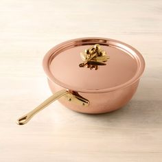 a pink pan with gold handles on a wooden table