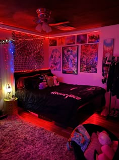 a bedroom with pink lights and posters on the wall