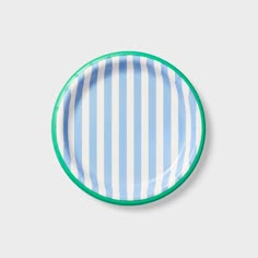 a blue and white striped plate with green rims on a grey background, top view