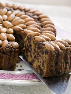 a cake with nuts on top is cut into pieces