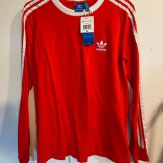 Brand New Red Adidas Long Sleeve Never Worn Red Long Sleeve T-shirt For Spring, Casual Long Sleeve Red T-shirt, Casual Red Long Sleeve T-shirt, Sporty University Red Tops For Spring, Sporty Long Sleeve Shirt For Spring, Casual Long Sleeve University Red T-shirt, University Red Sporty Top For Spring, Casual Three Stripes Tops For Fall, University Red Long Sleeve Casual T-shirt