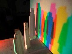 the shadows on the wall are cast by colorful light coming from it's shadow