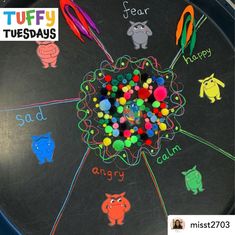 a black board with writing on it that says tuffy tuesdays and there is a bunch of pom poms in the center