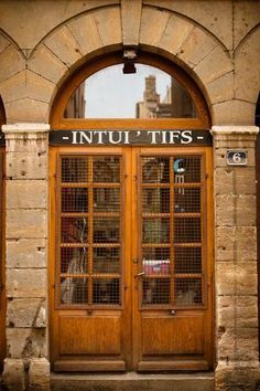 an old building with two wooden doors and the words intupities on it's side