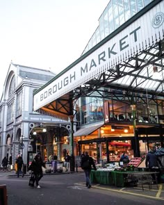 people are walking around in front of a market