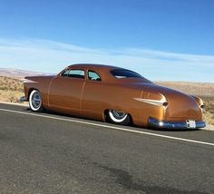 an old car is parked on the side of the road