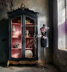 an old fashioned china cabinet with glass doors and flowers on it's display shelf