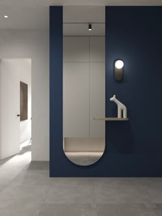 a blue and white bathroom with a mirror on the wall next to a shelf that is shaped like a giraffe