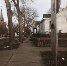 a street with houses and trees in the background