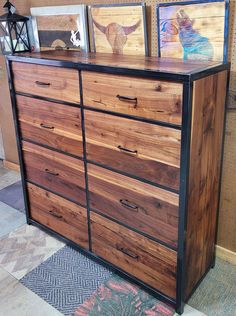 a wooden dresser with two pictures on top